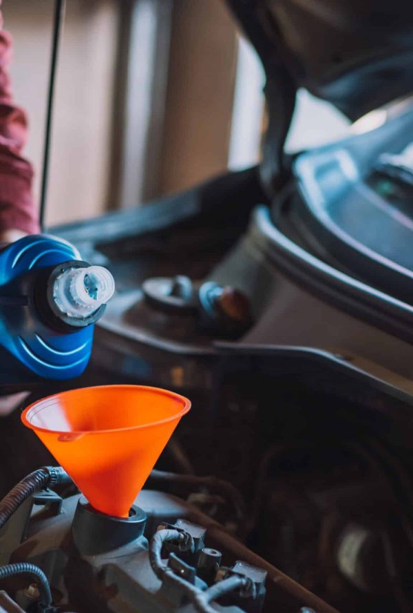 Mechanic pouring new oil into the engine.